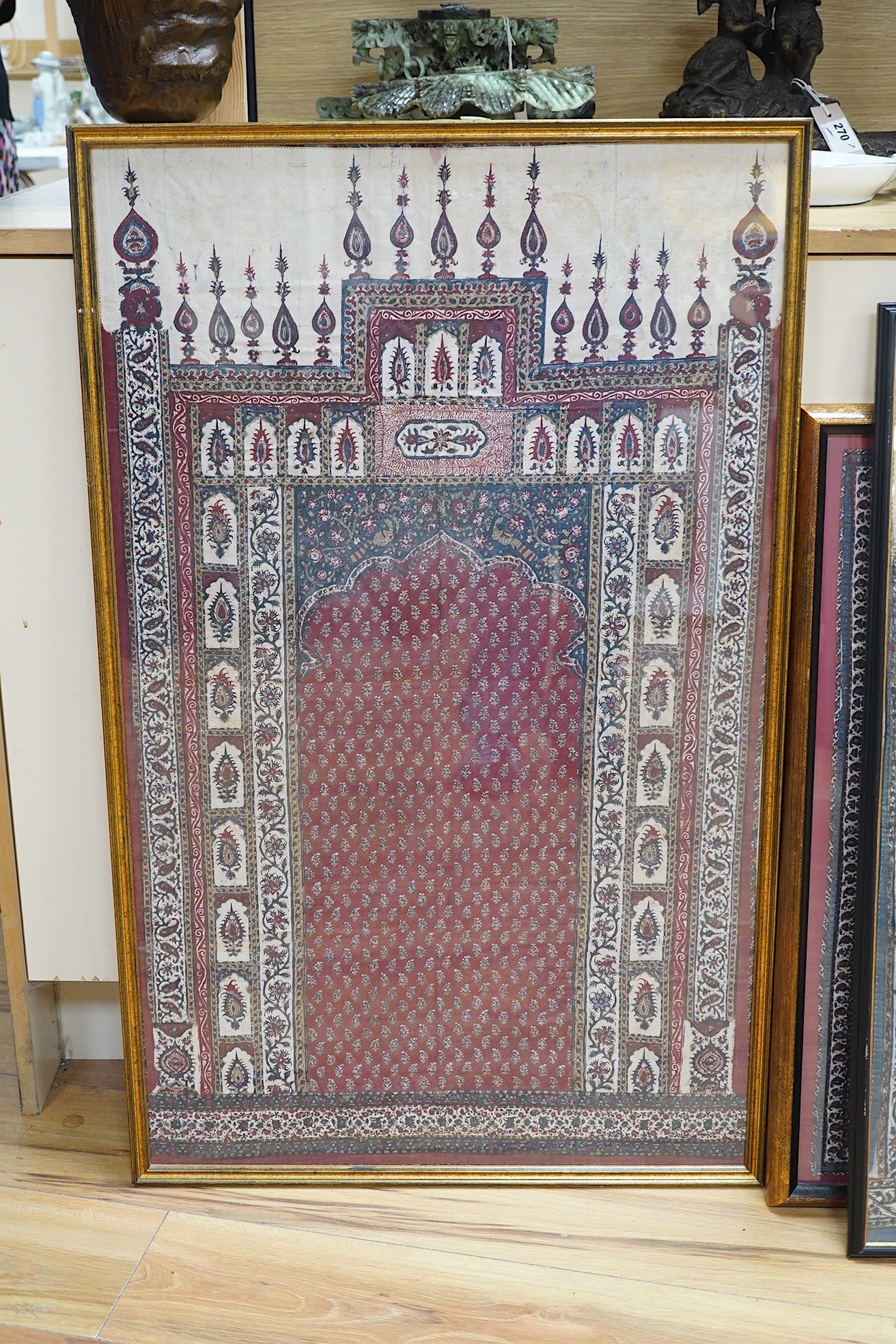 Two framed 19th century Indian Kalamkari boteh block printed prayer Niches, possibly from Machilitanam and a similar framed block printed square, possibly part of a table cover, largest 53cm wide x 67cm high (3). Conditi